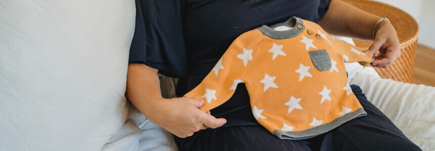 Schwangerschaft und Baby-Seite_860x300 Schwangerschaft und Baby. Babykleidung auf dem Babybauch.