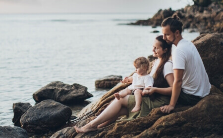 Reisen: Familie, die am Meer sitzt