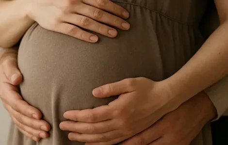 Hände von einem Paar die den Babybauch berühren.