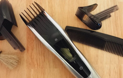Haarschneidemaschine mit verschiedenen Aufsätzen, einem Kamm und einem Haarpinsel.