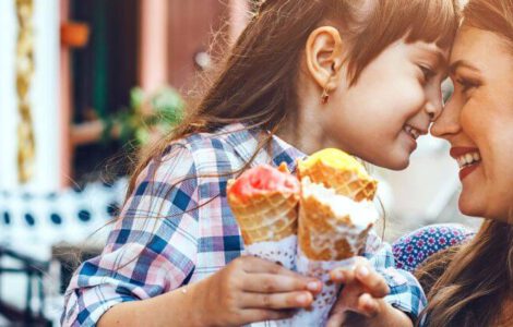 Mama mit ihrer Tochter, die gemeinsam ein Eis essen.