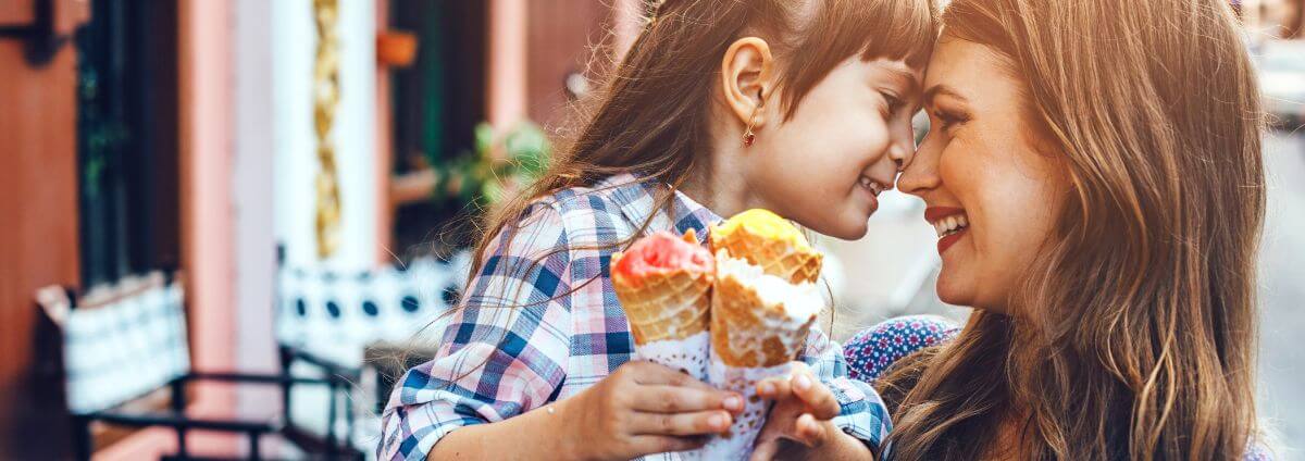 Mama mit ihrer Tochter, die gemeinsam ein Eis essen.